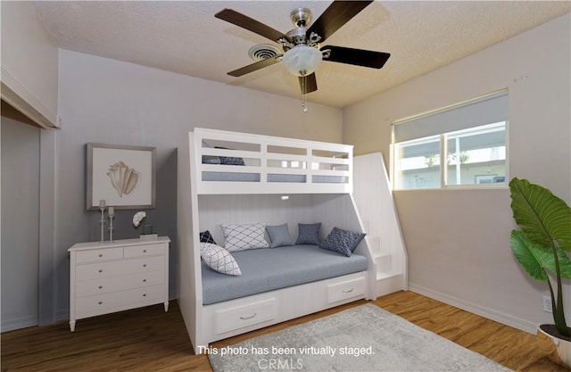 bedroom featuring wood-type flooring, a textured ceiling, and ceiling fan