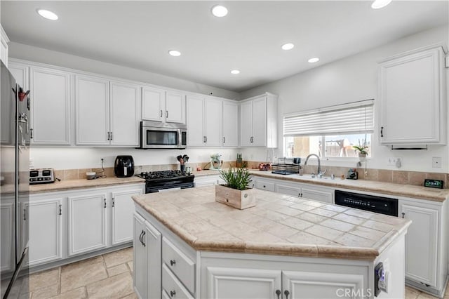 kitchen with white cabinetry, a center island, sink, and black appliances