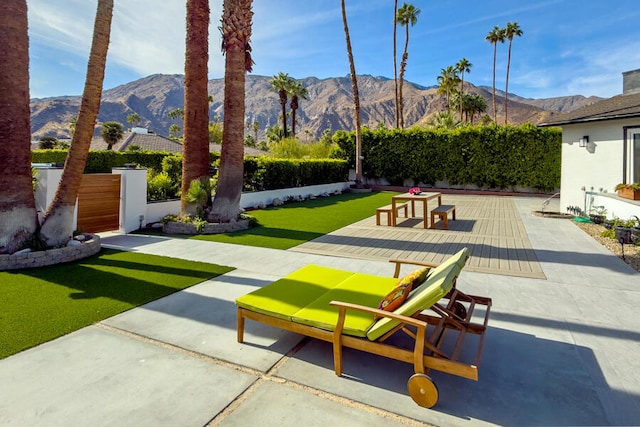 view of home's community featuring a mountain view, a yard, and a patio