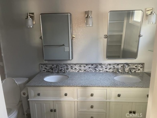 bathroom with tasteful backsplash, vanity, and toilet