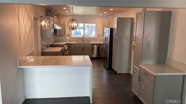 kitchen with decorative backsplash, gray cabinetry, stainless steel appliances, pendant lighting, and an inviting chandelier