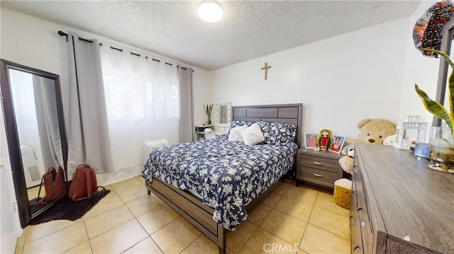 bedroom featuring light tile patterned floors and a textured ceiling