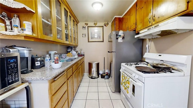 kitchen featuring white range with gas stovetop, sink, and light tile patterned floors