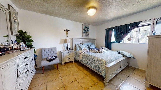 bedroom with a textured ceiling and light tile patterned flooring