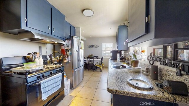 kitchen featuring stainless steel refrigerator, sink, black range with gas stovetop, water heater, and light tile patterned floors