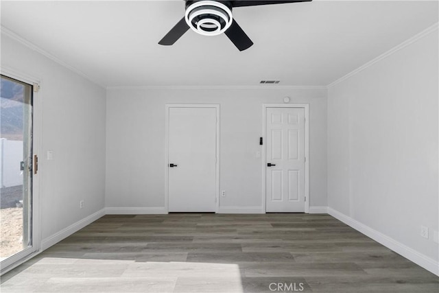 spare room featuring ceiling fan, crown molding, and light wood-type flooring