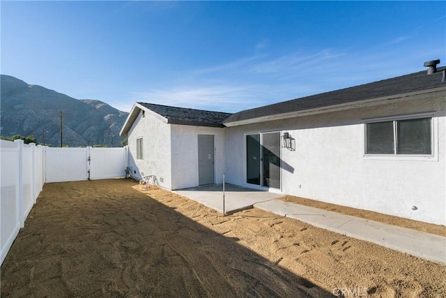 rear view of house with a mountain view and a patio area