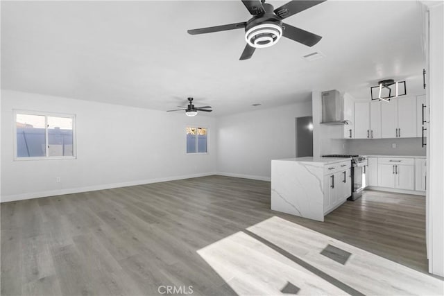 unfurnished living room featuring wood-type flooring and ceiling fan