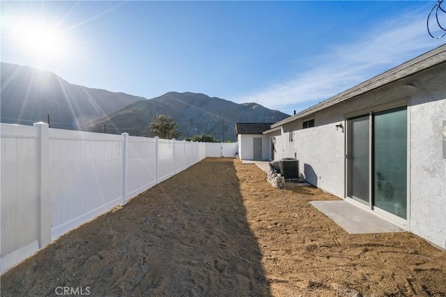 view of yard featuring a mountain view and central AC unit