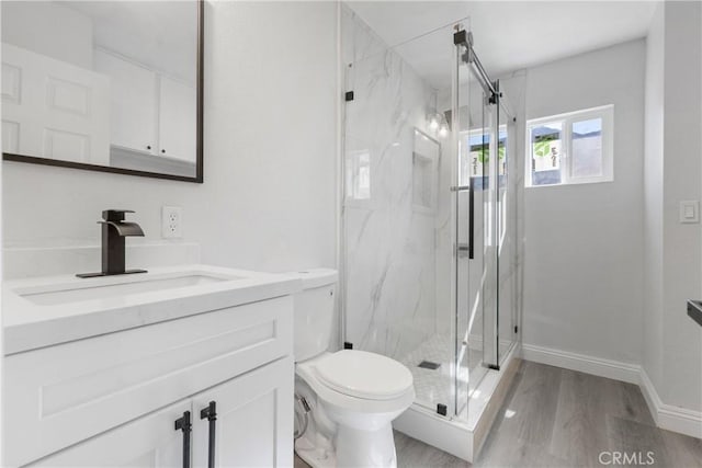 bathroom with vanity, hardwood / wood-style flooring, toilet, and a shower with shower door