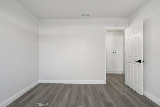 unfurnished room featuring dark wood-type flooring