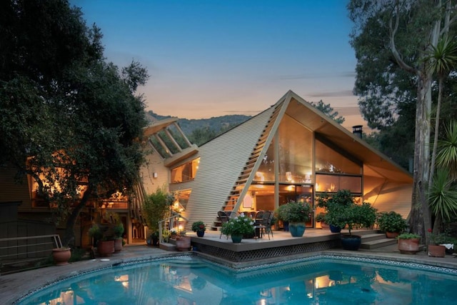 pool at dusk featuring a patio area