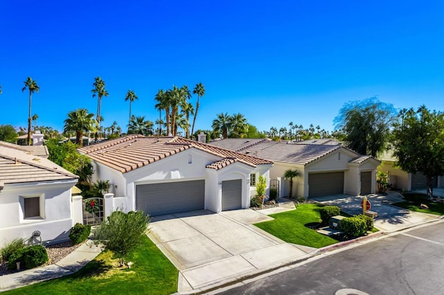 mediterranean / spanish home featuring a garage and a front yard