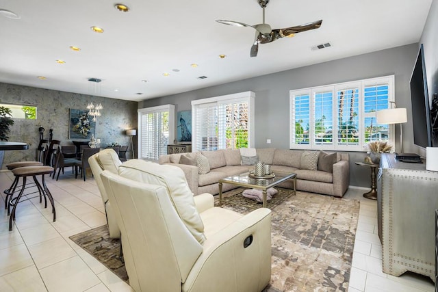 living room with ceiling fan with notable chandelier and light tile patterned floors