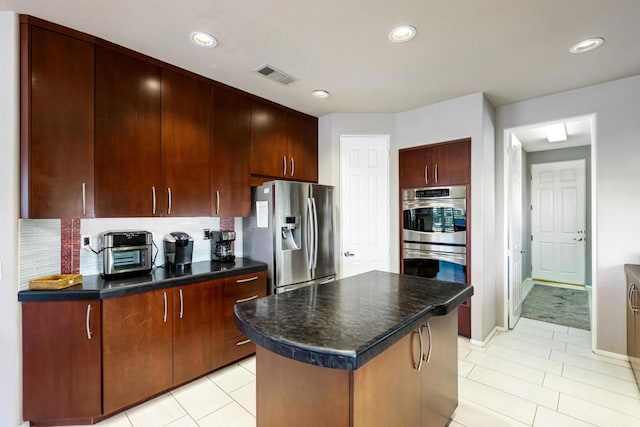 kitchen featuring decorative backsplash, light tile patterned flooring, stainless steel appliances, and a kitchen island