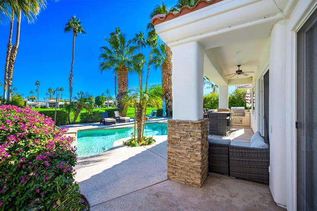 view of swimming pool with exterior kitchen, a patio, and ceiling fan