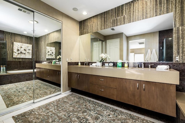 bathroom featuring tile patterned flooring, vanity, and a tub