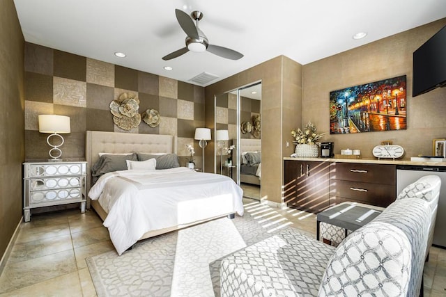 tiled bedroom featuring tile walls, ceiling fan, and a closet