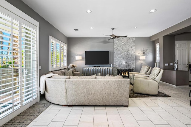 living room with ceiling fan, light tile patterned flooring, and a fireplace