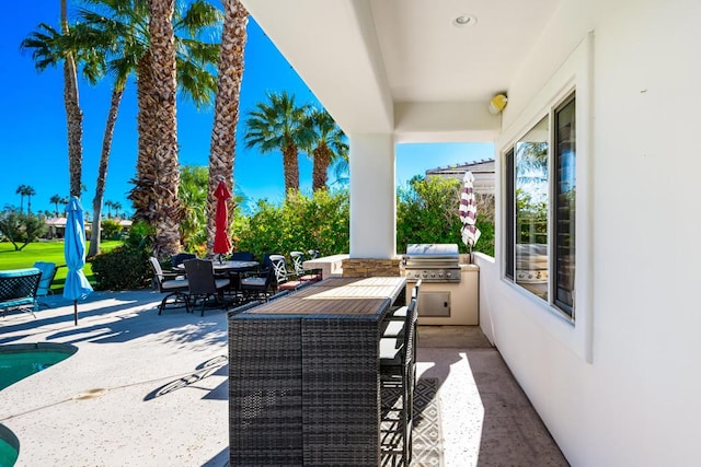 view of patio / terrace with a pool, grilling area, and an outdoor kitchen