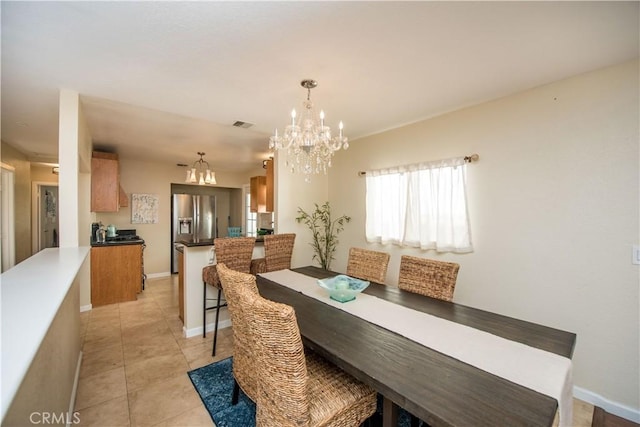 dining area featuring light tile patterned flooring and an inviting chandelier