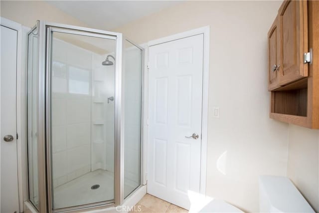 bathroom featuring tile patterned floors and a shower with shower door