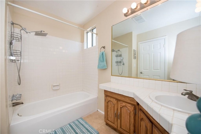 bathroom featuring tile patterned flooring, vanity, and tiled shower / bath combo