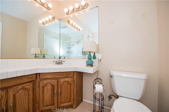 bathroom with vanity, toilet, and decorative backsplash