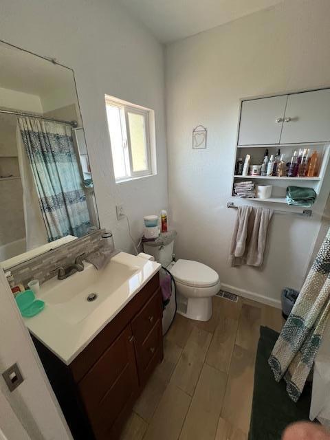 full bathroom featuring toilet, vanity, and shower / tub combo with curtain