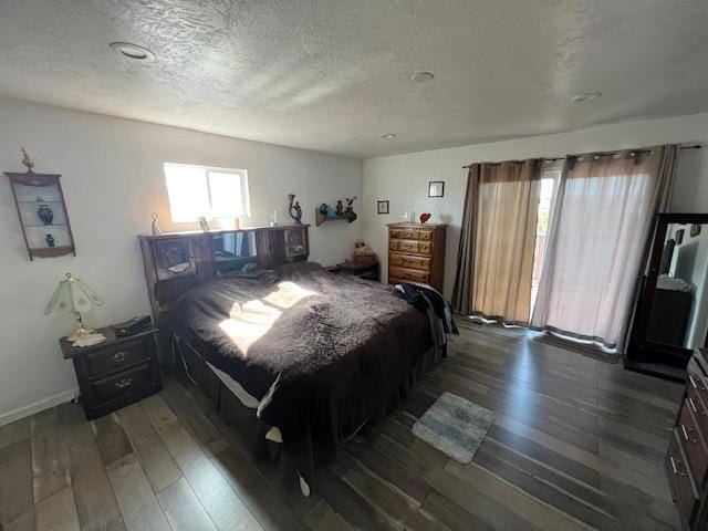 bedroom with dark hardwood / wood-style floors, multiple windows, and a textured ceiling