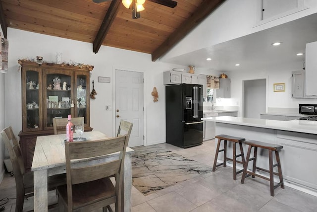 dining room featuring ceiling fan, wood ceiling, and vaulted ceiling with beams