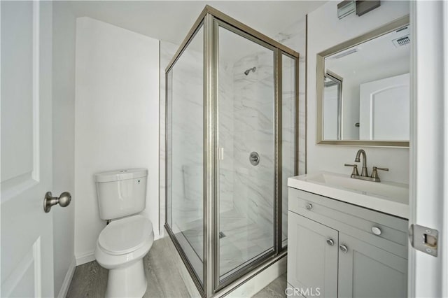 full bathroom with toilet, wood finished floors, vanity, baseboards, and a marble finish shower