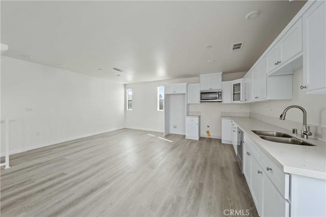 kitchen featuring light hardwood / wood-style floors, white cabinetry, and sink