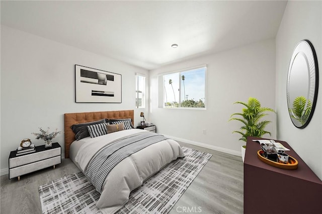 bedroom with baseboards and wood finished floors