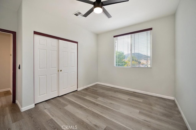 unfurnished bedroom featuring light wood-type flooring, a closet, and ceiling fan