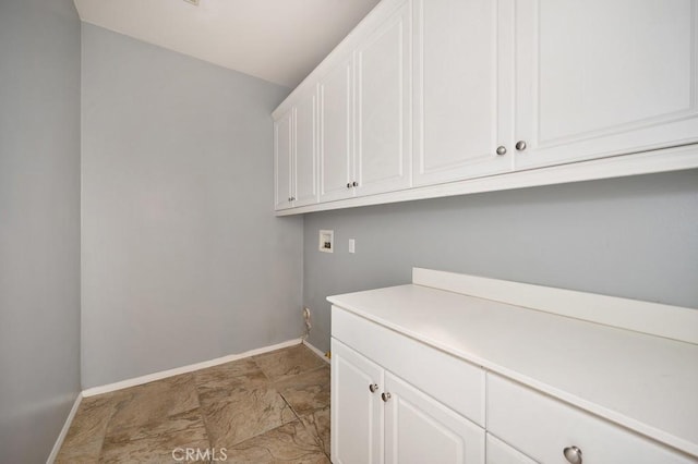 clothes washing area with cabinets and washer hookup