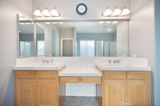 bathroom featuring vanity, tile patterned floors, and a shower with shower door