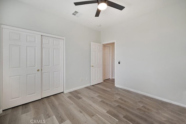 unfurnished bedroom featuring a closet, light hardwood / wood-style floors, and ceiling fan