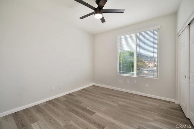 unfurnished bedroom featuring wood-type flooring, a closet, and ceiling fan