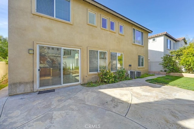 rear view of house with central air condition unit and a patio