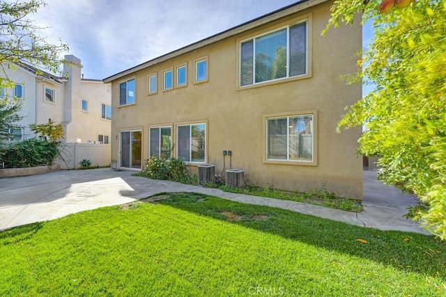 back of house with a yard, a patio, and central AC