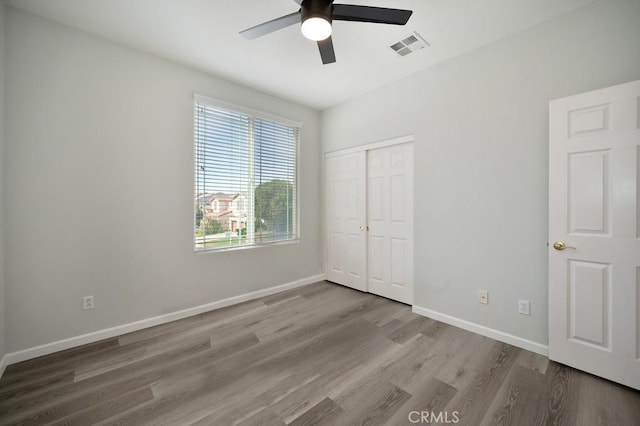 unfurnished bedroom featuring light wood-type flooring, a closet, and ceiling fan