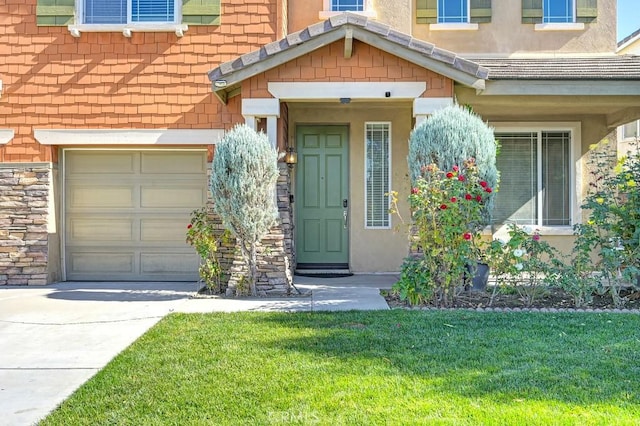 entrance to property featuring a garage and a lawn