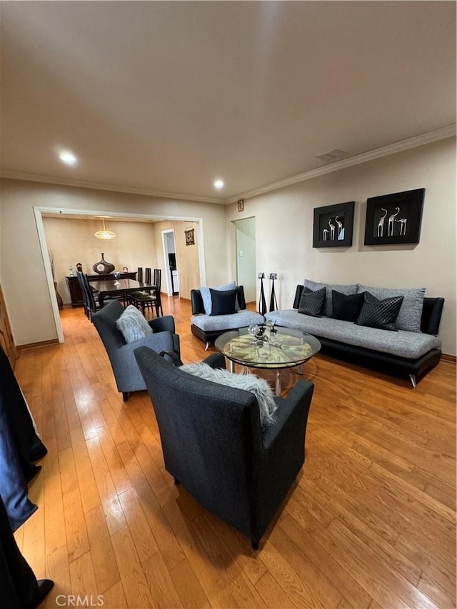 living room with ornamental molding and light wood-type flooring