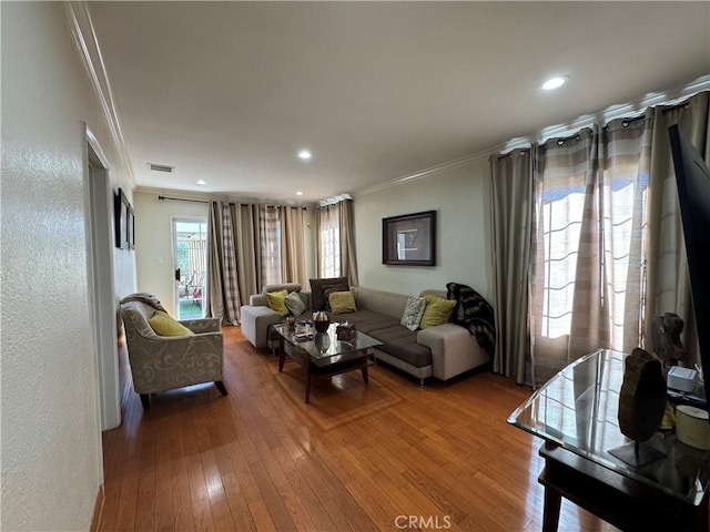 living room featuring hardwood / wood-style flooring and crown molding