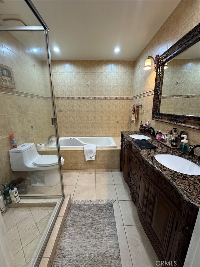 bathroom with tile patterned floors, vanity, tile walls, and independent shower and bath