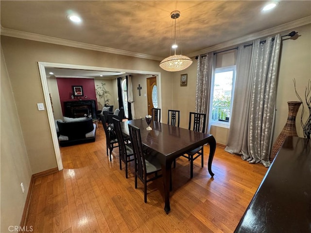 dining room with an inviting chandelier, light hardwood / wood-style flooring, and ornamental molding