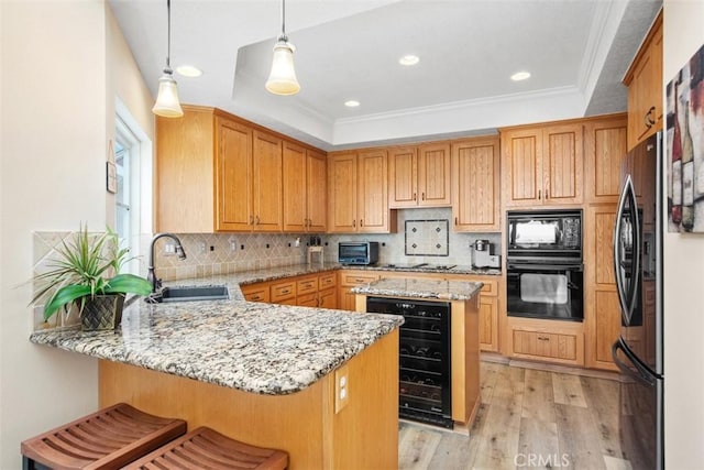 kitchen with kitchen peninsula, light wood-type flooring, sink, black appliances, and wine cooler