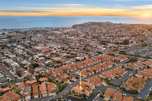 aerial view at dusk featuring a water view