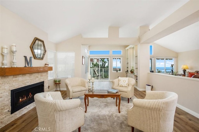 living area with a fireplace, dark hardwood / wood-style floors, and vaulted ceiling